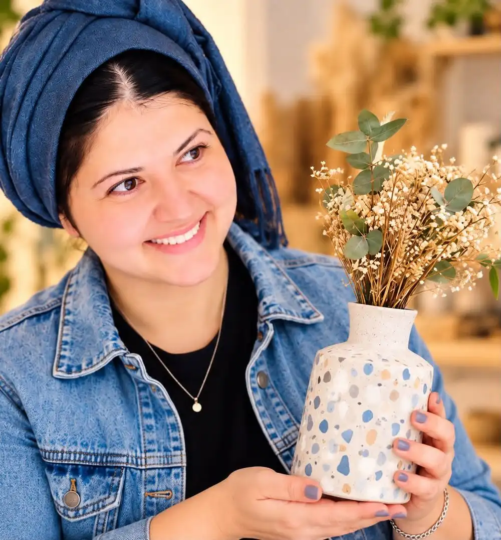 כרמית פרז מחזיקה אגרטל טרצו בעבודת יד
